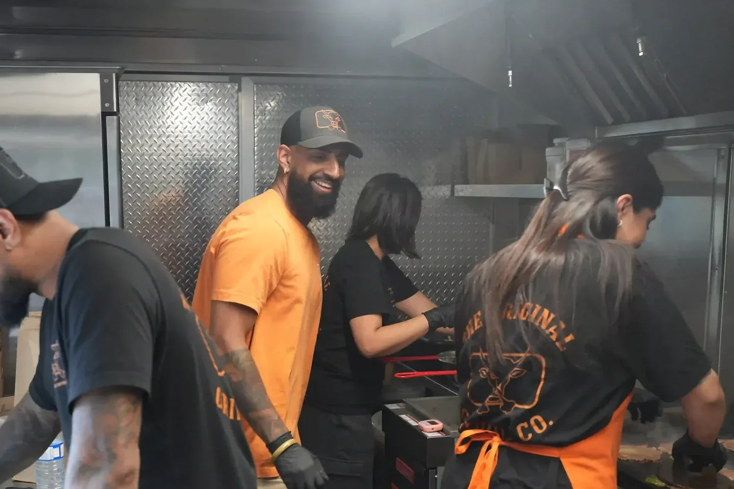 Team of cooks working together inside the food trailer kitchen